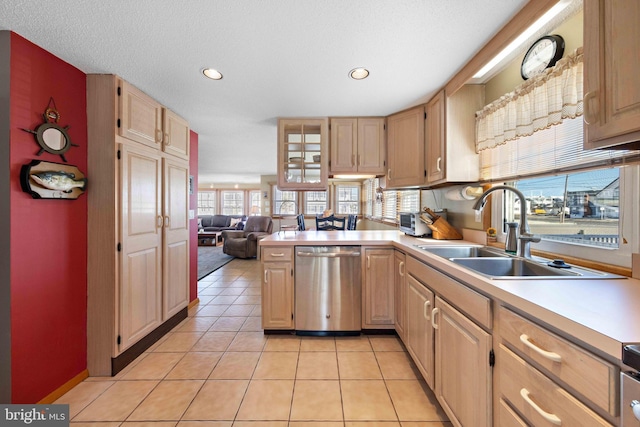 kitchen with dishwasher, light tile patterned floors, sink, and light brown cabinetry