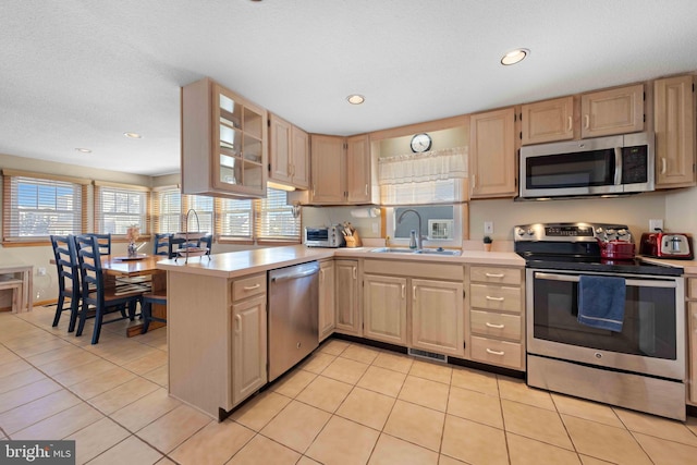 kitchen with light brown cabinets, sink, and stainless steel appliances