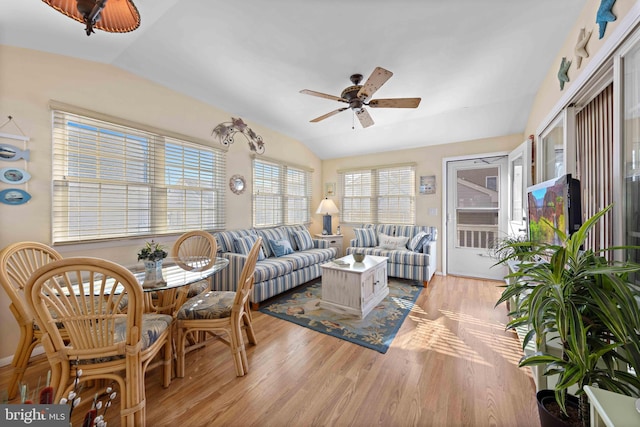 living room with ceiling fan, lofted ceiling, and light wood-type flooring