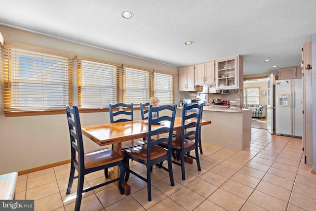 dining area with light tile patterned floors and a textured ceiling