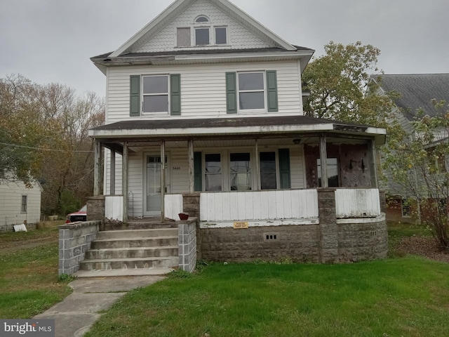 view of front of house with covered porch and a front lawn