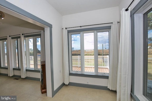 doorway to outside with plenty of natural light and light tile patterned floors