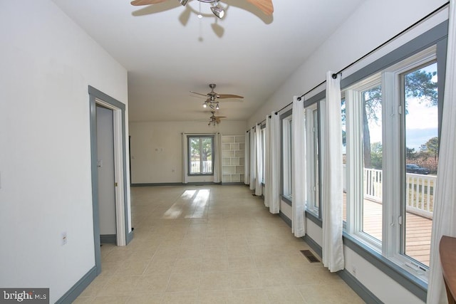 corridor featuring plenty of natural light and light tile patterned floors