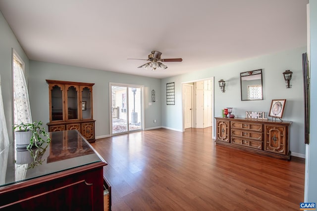 living room featuring ceiling fan and dark hardwood / wood-style flooring