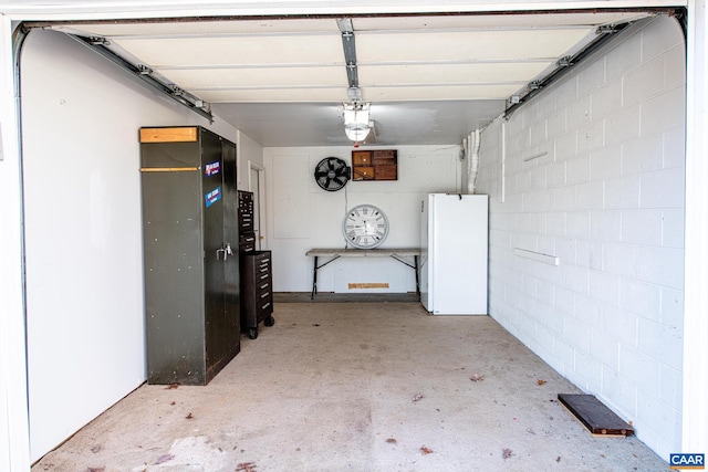 garage with white fridge and a garage door opener