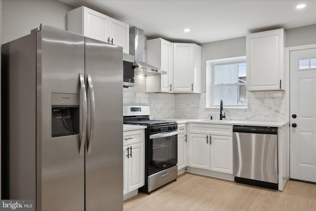 1155 Washington Blvd, Baltimore, MD 21230 - kitchen with stainless steel appliances, wall chimney range hood, light wood-style floors, light countertops, and white cabinets
