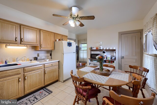 kitchen featuring ceiling fan, sink, light tile patterned floors, and white refrigerator