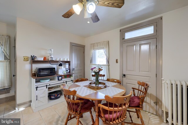 tiled dining area with radiator and ceiling fan