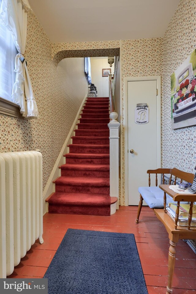 stairway with wood-type flooring and radiator heating unit