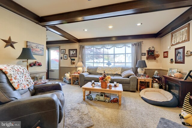 carpeted living room with plenty of natural light and beam ceiling