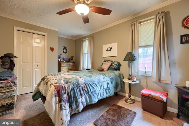 carpeted bedroom with a wood stove, ceiling fan, ornamental molding, a textured ceiling, and a closet