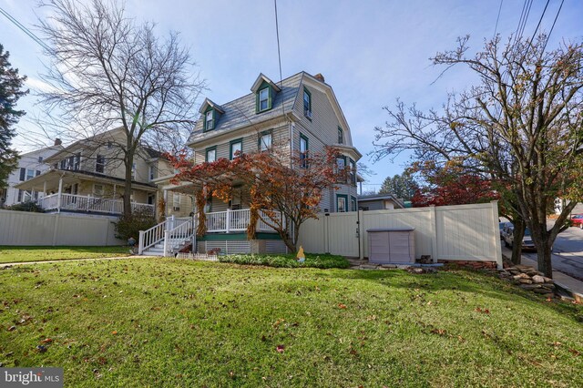 rear view of house with a porch and a lawn