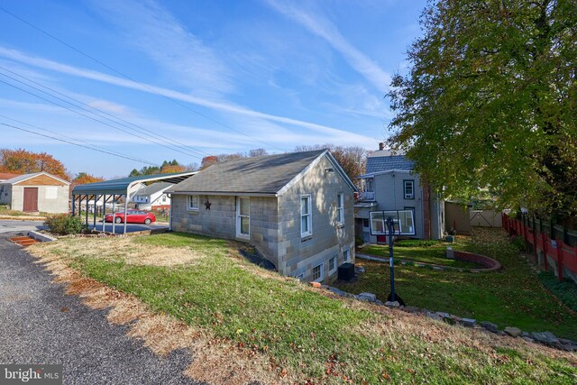 view of home's exterior featuring a carport and a yard