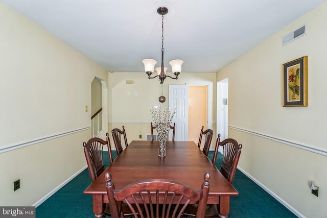 dining room featuring a chandelier and dark carpet