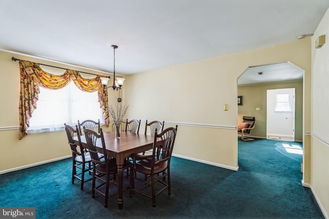 dining room featuring an inviting chandelier and dark carpet