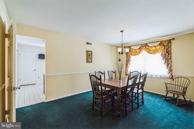 dining room featuring a chandelier and dark carpet