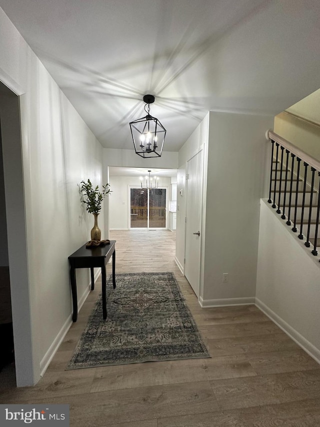 hall with hardwood / wood-style flooring and a chandelier