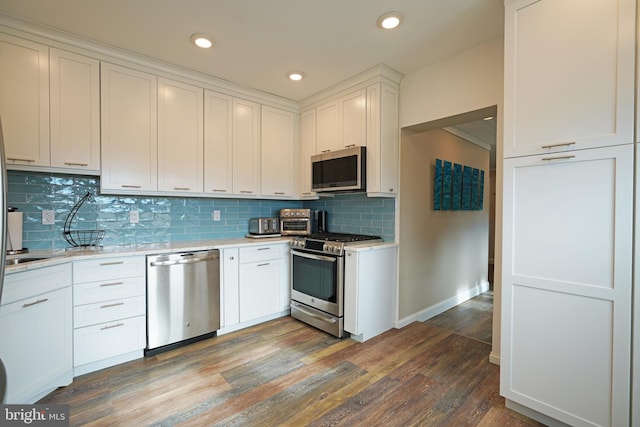 kitchen with tasteful backsplash, stainless steel appliances, dark hardwood / wood-style floors, and white cabinets