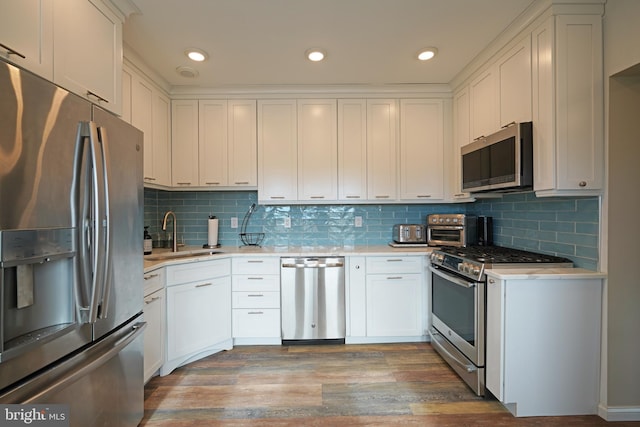 kitchen featuring sink, hardwood / wood-style floors, white cabinets, and appliances with stainless steel finishes