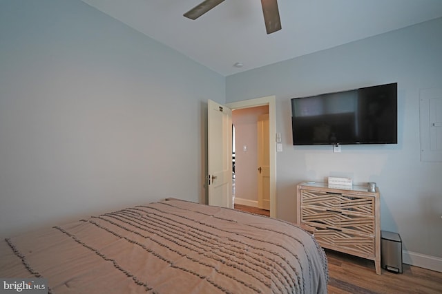 bedroom with hardwood / wood-style flooring, electric panel, and ceiling fan