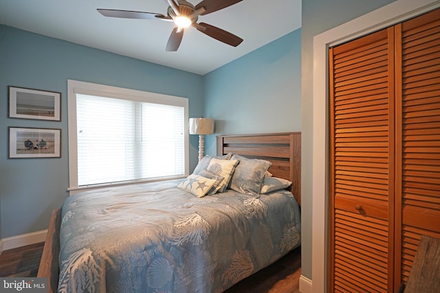 bedroom with dark wood-type flooring, ceiling fan, and a closet