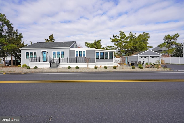 view of front of home with a garage and an outbuilding