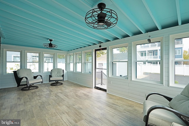 sunroom with lofted ceiling with beams and ceiling fan