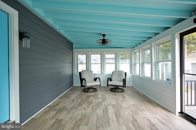 unfurnished sunroom featuring beam ceiling and a healthy amount of sunlight