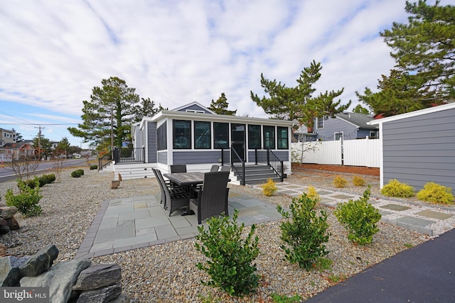 rear view of property featuring a patio and a sunroom