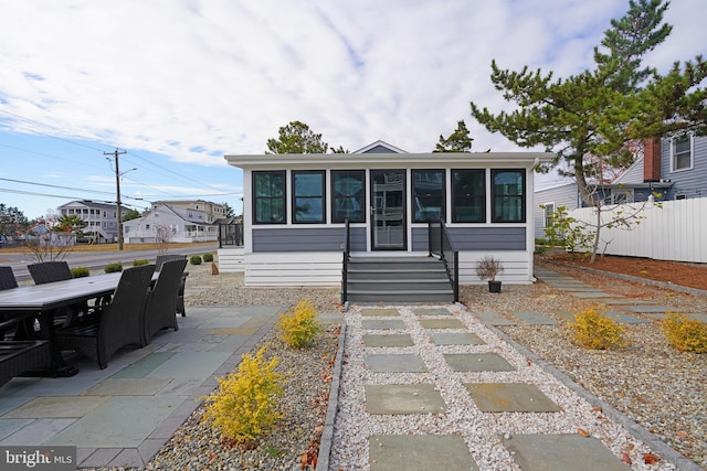 view of front facade featuring a sunroom and a patio area