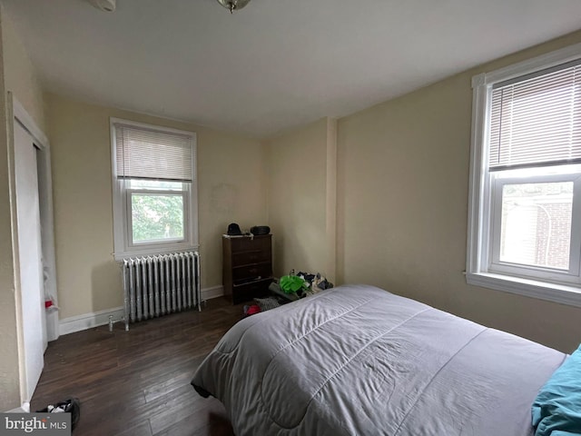 bedroom with radiator and dark wood-type flooring