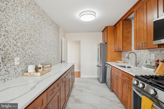 kitchen featuring light stone countertops, stainless steel appliances, tasteful backsplash, and sink