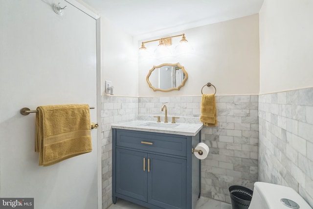 bathroom with vanity and tile walls