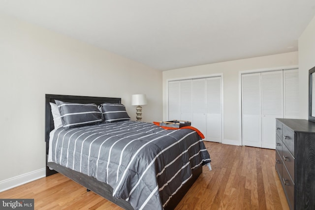 bedroom with hardwood / wood-style floors and multiple closets