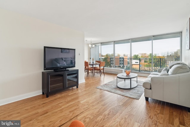 living room featuring light hardwood / wood-style floors, floor to ceiling windows, a healthy amount of sunlight, and a notable chandelier