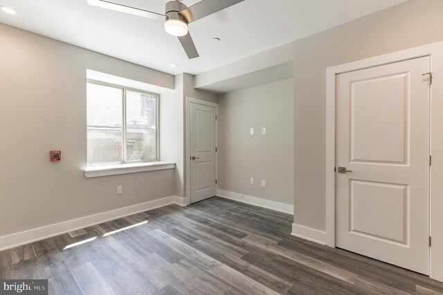 unfurnished bedroom featuring ceiling fan and dark wood-type flooring