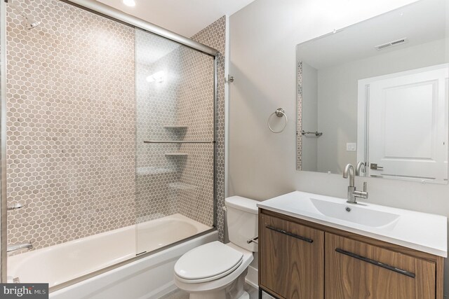 full bathroom with vanity, toilet, and enclosed tub / shower combo