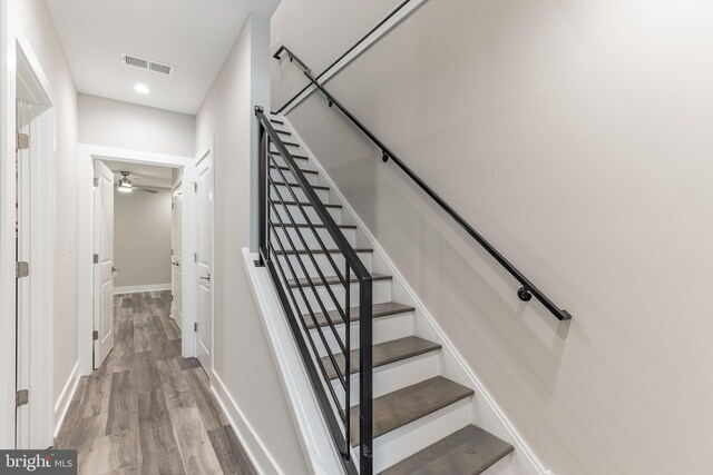 stairs with ceiling fan and wood-type flooring