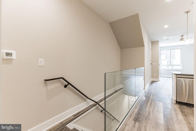 hall with light hardwood / wood-style flooring and lofted ceiling