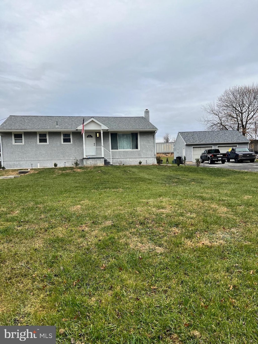 ranch-style home with a front lawn and covered porch