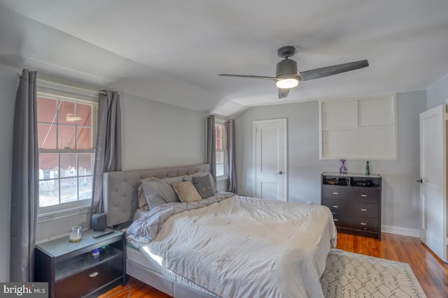 bedroom with ceiling fan, vaulted ceiling, and light wood-type flooring