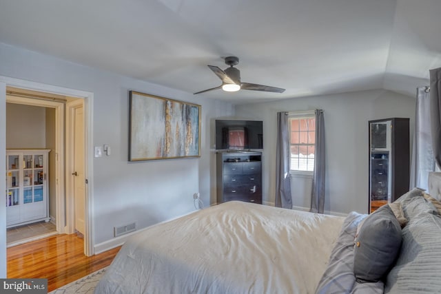 bedroom featuring ceiling fan, lofted ceiling, and light wood-type flooring