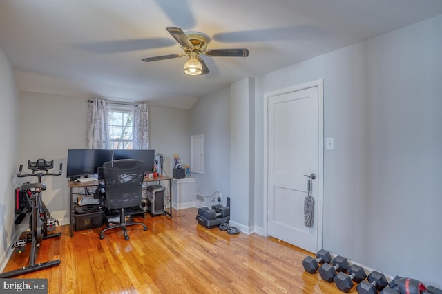 home office featuring light hardwood / wood-style floors, vaulted ceiling, and ceiling fan