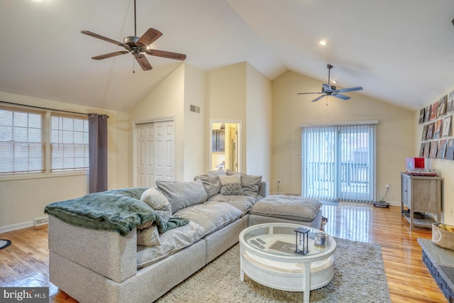 living room with ceiling fan, high vaulted ceiling, and light wood-type flooring