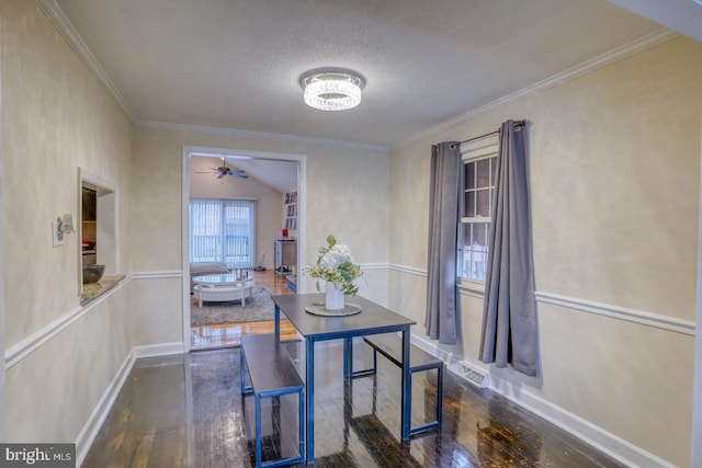 dining room featuring a textured ceiling, crown molding, lofted ceiling, and dark wood-type flooring