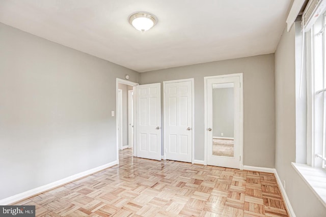 unfurnished bedroom featuring light parquet flooring