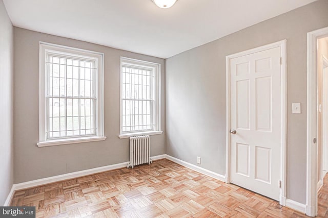 unfurnished room with light parquet floors and radiator