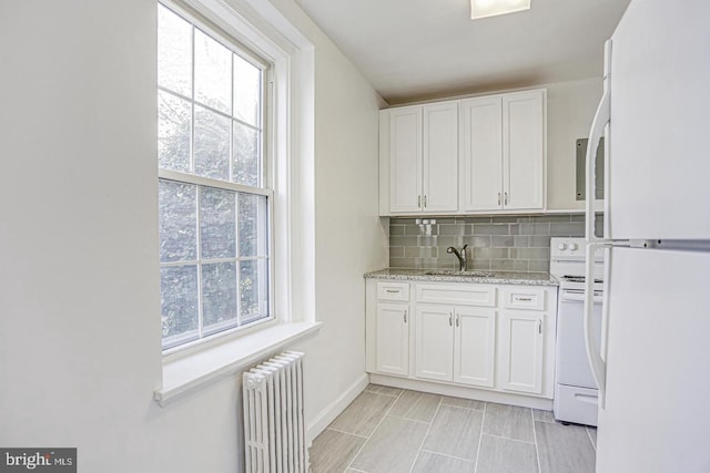 kitchen featuring white cabinets, white appliances, sink, and radiator