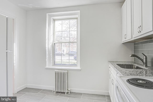 laundry area featuring washer hookup, radiator heating unit, and sink