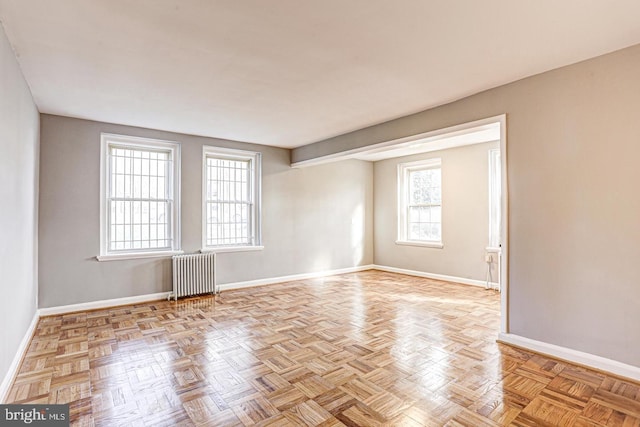 spare room with radiator and light parquet flooring